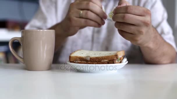 Un homme mange un sandwich dans un café — Video