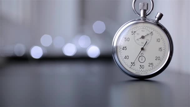 Reloj sobre un fondo borroso con bokeh — Vídeos de Stock