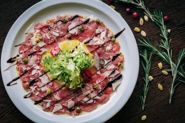 Carpaccio beyaz bir tabak içinde üstten görünüm