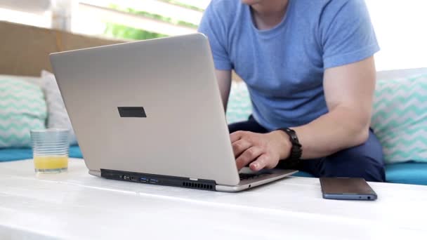 Jonge man werken met laptop in cafe — Stockvideo