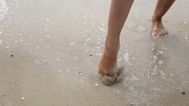 Kız kum deniz kenarında üzerinde bir kalp çizer