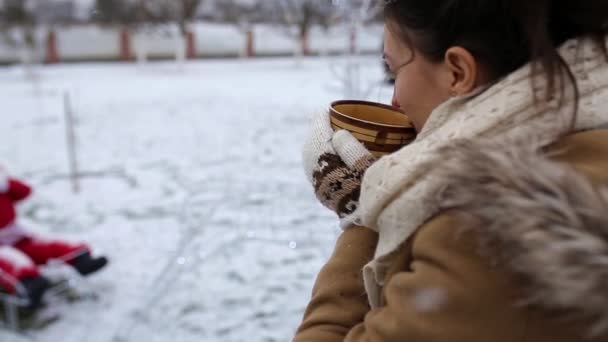Dziewczyna pije herbatę zimą na świeżym powietrzu — Wideo stockowe