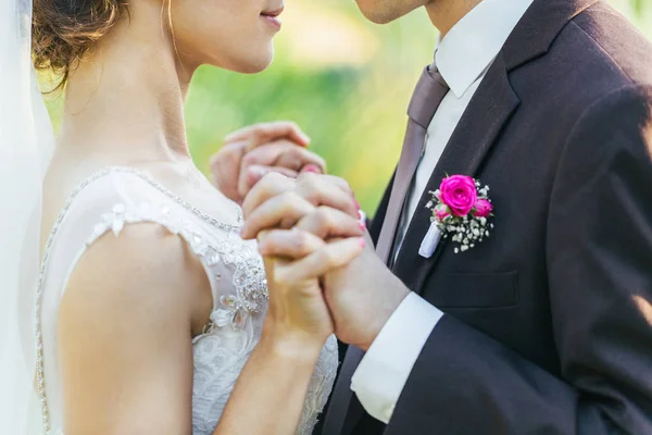 Newlyweds are holding each others hands