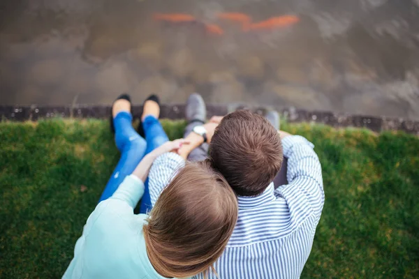 湖のほとりに座って抱いてカップル — ストック写真