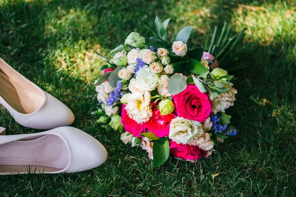 Svatební kytice s tuflmi ležící na trávě — Stock fotografie