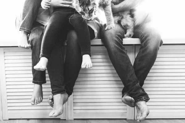 Family sitting with children on the windowsill — Stock Photo, Image