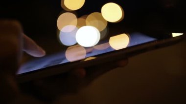 Akşamları insanların elindeki akıllı telefonun yakın görüntüsü