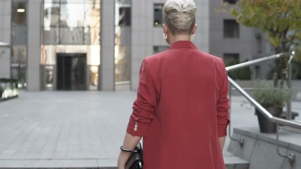 Slow Motion Blonde Red Jacket White Earrings Passing Building — 비디오