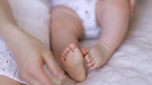 Μαμά Χαϊδεύει Απαλά Πόδια Του Μωρού Κάθεται Στον Καναπέ — Αρχείο Βίντεο