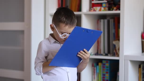 Pequeño Niño Con Gafas Blancas Está Jugando Médico Escribir Notas — Vídeo de stock