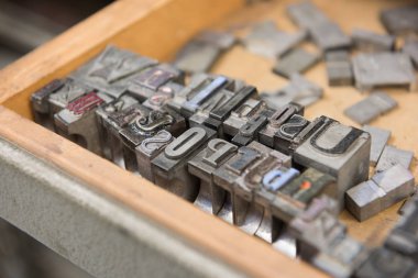 Bokeh ile yıpranmış ahşap çekmece arka plan karşı Vintage kurşun letterpress baskı blokları.