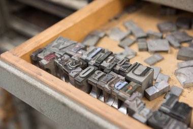 Bokeh ile yıpranmış ahşap çekmece arka plan karşı Vintage kurşun letterpress baskı blokları.