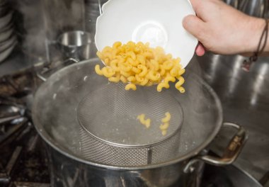 Pişmemiş Makarna makarnayı buharlı sıcak bir tencereye damlatma.