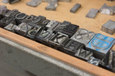 Bokeh ile yıpranmış ahşap çekmece arka plan karşı Vintage kurşun letterpress baskı blokları.