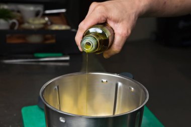 Sızma zeytinyağı metal bir karıştırma kabına dökülüyor.