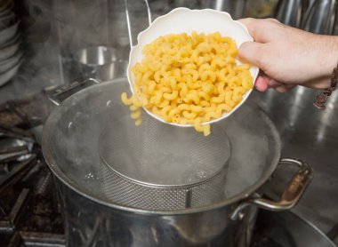 Pişmemiş Makarna makarnayı buharlı sıcak bir tencereye damlatma.