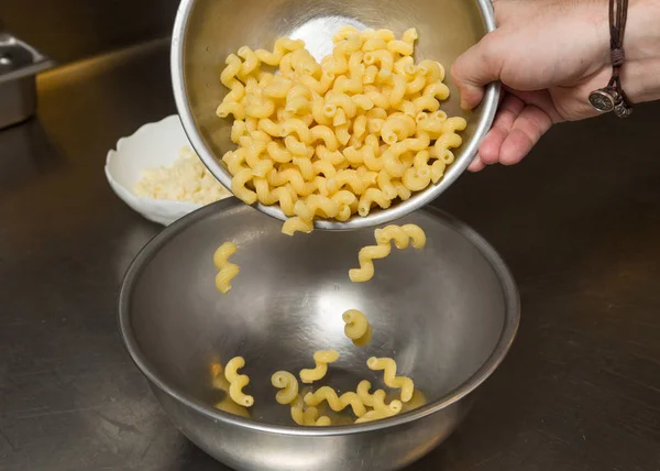 cooked Macaroni pasta being transferred to a meal bowl