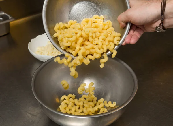 cooked Macaroni pasta being transferred to a meal bowl