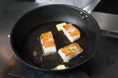 Tavada kızarmış altın balık fileto küpleri, gerçek tereyağı nda kızartma, olmayan bir sopa rustik tavada.