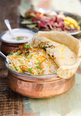 Otantik tavuk biryani naan ekmek, güzel kokulu pilav pirinç ve metal bir tencerede yoğurt ile servis.