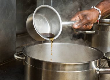 sıcak sığır eti ve tavuk pişirme suyu bir tavaya dökülür varlık