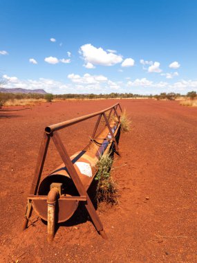 bir eski paslı sığır Besleyici, Avustralya outback sert kurak kırmızı manzara çalı.