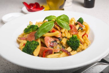 Bir lezzetli taze gurme İtalyan strozzapreti makarna yemek, pancetta, İtalyan sosisi, brokoli, sebze, taze fesleğen ile tepesinde.