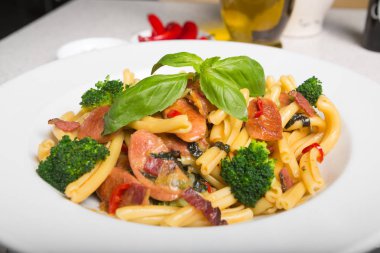 Bir lezzetli taze gurme İtalyan strozzapreti makarna yemek, pancetta, İtalyan sosisi, brokoli, sebze, taze fesleğen ile tepesinde.