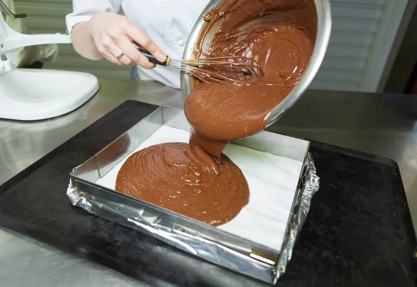 stock image Creamy rich dark chocolate dessert sauce being poured into a baking tray.