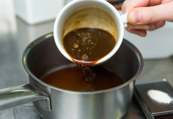 Rich strong italian espresso coffee being poured into a metal pan ready for boiling.