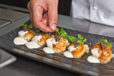 Organik tarak kereviz püresi ile servis, lezzetli pan katılaşmış, havyar, maydanoz ve beyaz krema sos şarap. Profesyonel olarak sunulan ve sığ bir alan derinliği ile vurdu.