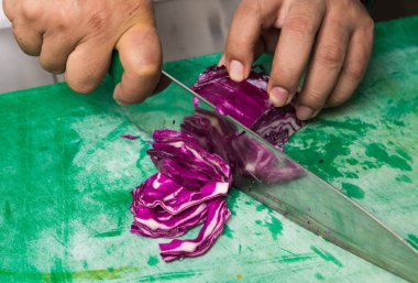 Dilimlenmiş ve doğranmış yeşil sebze kesme tahtasında organik kırmızı lahana.