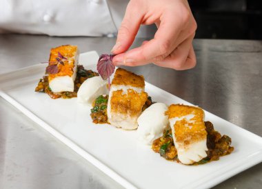 Taze pan katılaşmış, gevrek altın cod curried karnabahar, ıspanak ve patates üzerinde servis fileto, balık. Bir güzel deniz ürünleri yemek.