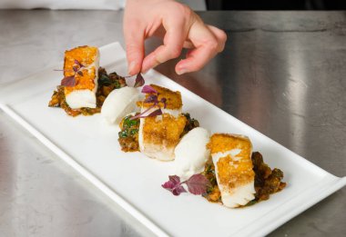 Taze pan katılaşmış, gevrek altın cod curried karnabahar, ıspanak ve patates üzerinde servis fileto, balık. Bir güzel deniz ürünleri yemek.