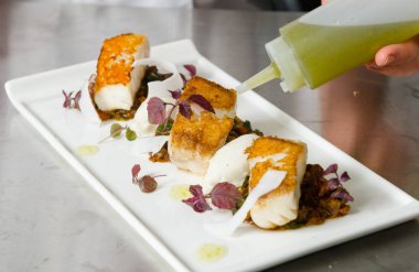 Taze pan katılaşmış, gevrek altın cod curried karnabahar, ıspanak ve patates üzerinde servis fileto, balık. Bir güzel deniz ürünleri yemek.