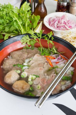 Geleneksel Vietnam sığır eti ve tavuk pho sokak gıda taze otlar tarafından çevrili, kâse. Pho et, otlar, biber, kişniş ve köfte oluşan bir Vietnamlı erişte çorbası mı