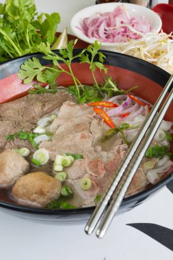Geleneksel Vietnam sığır eti ve tavuk pho sokak gıda taze otlar tarafından çevrili, kâse. Pho et, otlar, biber, kişniş ve köfte oluşan bir Vietnamlı erişte çorbası mı