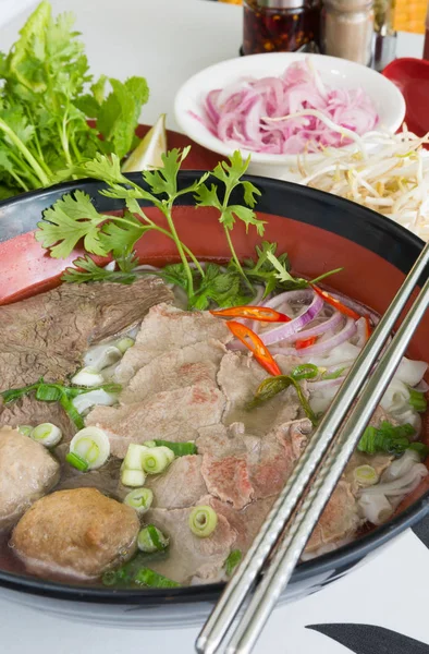 Geleneksel Vietnam sığır eti ve tavuk pho sokak gıda taze otlar tarafından çevrili, kâse. Pho et, otlar, biber, kişniş ve köfte oluşan bir Vietnamlı erişte çorbası mı