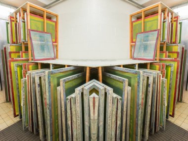 Baskıya hazır ahşap rafta saklanan ipek ekranlı baskı ekranları.