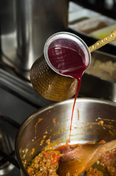 Сладкий смешанный гранатовый соус наливают в горячую сковородку с ингредиентами — стоковое фото