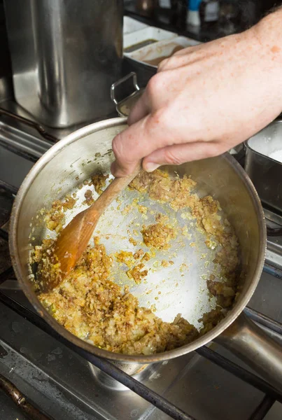 Polvo de cúrcuma mezclado en una sartén de ajo picado y cebolla finamente cortada en rodajas. Paso a paso receta de cocina — Foto de Stock