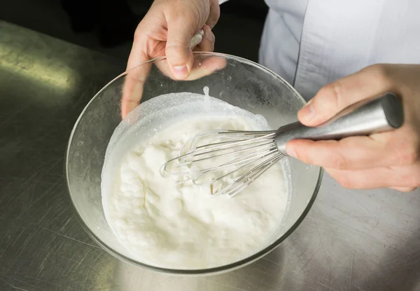Egy gyönyörű, gazdag és krémes, fehér felvert tejszín elegyét, hogy felvert egy nagy tálban kézi — Stock Fotó