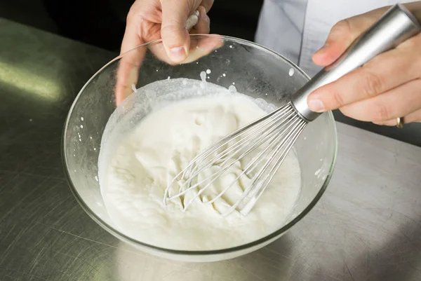 Egy gyönyörű, gazdag és krémes, fehér felvert tejszín elegyét, hogy felvert egy nagy tálban kézi — Stock Fotó