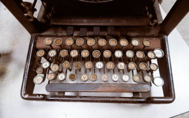 Paslı, eski, çürüyen, antika tipli bir yazar masanın üstünde bir ofiste oturuyordu. Korkunç terk edilmiş korku hikayesi daktilosu, turuncu ve kahverengi pas. hikaye anlatma ekipmanı                 