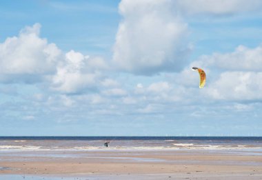 Okyanus uçurtmasında bir adam destansı mavi gökyüzüne karşı sörf yapıyor. Uçurtma sörfü adrenalin ekstrem spordur ve sürücüye doğayla özgürlük duygusu verir..                               