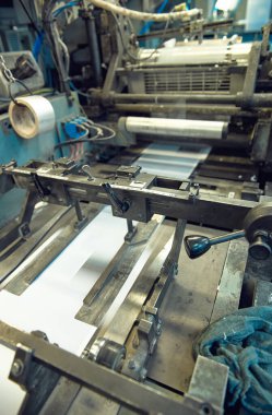 Uluslararası dağıtım için kağıt zarflar yapan endüstriyel bir zarf yapma makinesi. Kağıt zarflarının seri üretimi için otomatik mühendislik mekanizması.