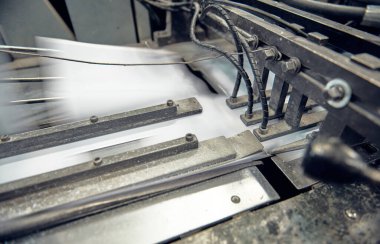 Uluslararası dağıtım için kağıt zarflar yapan endüstriyel bir zarf yapma makinesi. Kağıt zarflarının seri üretimi için otomatik mühendislik mekanizması.