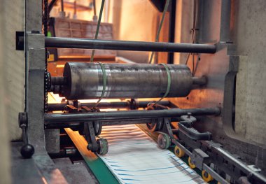 Uluslararası dağıtım için kağıt zarflar yapan endüstriyel bir zarf yapma makinesi. Kağıt zarflarının seri üretimi için otomatik mühendislik mekanizması.