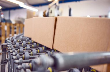 Tam otomatik bir çevrimiçi perakende satış deposunda endüstriyel paten kayışında teslimat paketleri. Ticari çevrimiçi satışları insan işgücü olmadan kolayca hareket ettirebilmek için paten taşıyıcı..