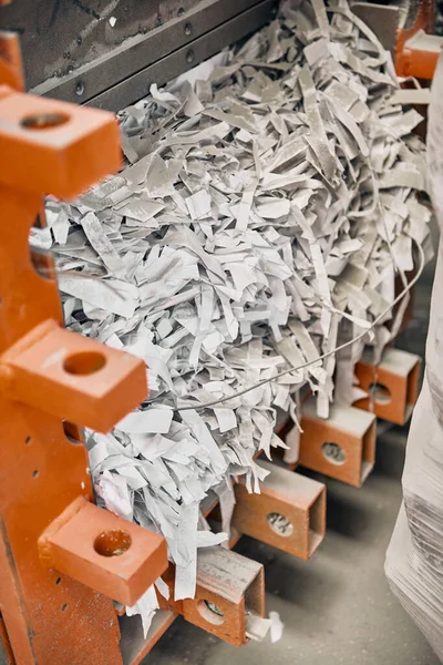 A paper recycling factory plant shredding machine, shredding waste paper into square bails, ready to be pulped and reused. Recycle waste materials to offset pollution and save the planet.